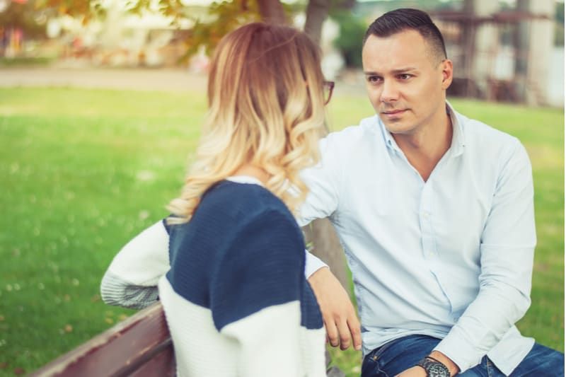 para rozmawiająca w parku poważnie siedząca na ławce