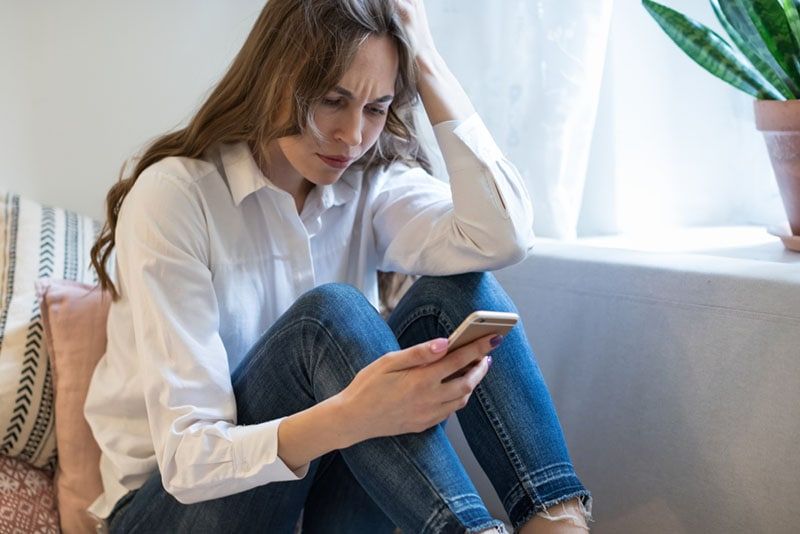 người phụ nữ tức giận nhìn vào điện thoại
