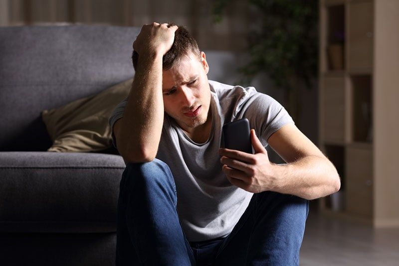 người đàn ông buồn đang nhắn tin