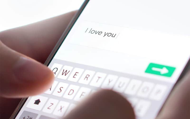Mãos escrevendo eu te amo mensagem em um telefone inteligente