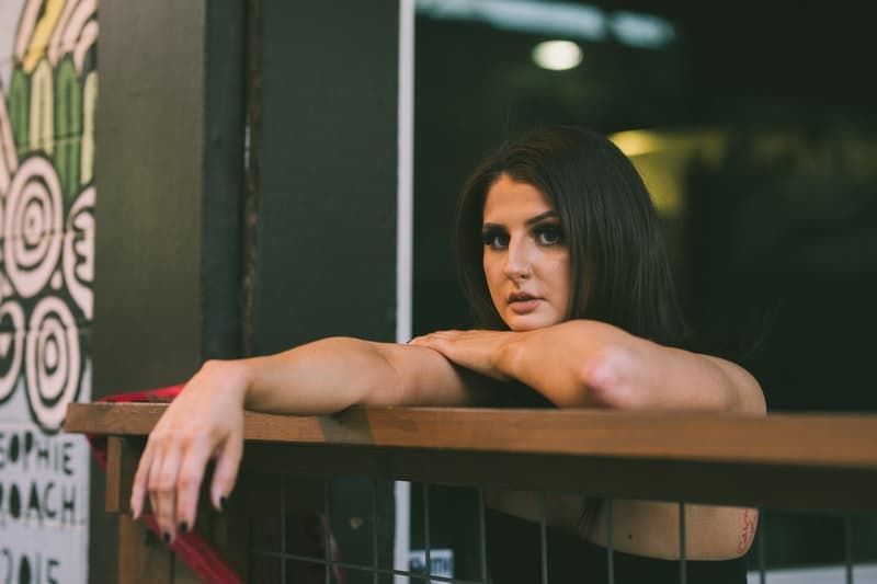 žena opierajúca sa o hnedú stenu