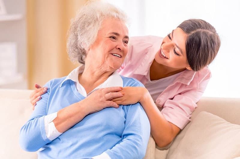 cura de la dona gran asseguda al sofà