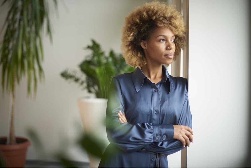 jonge Afro-Amerikaanse vrouw staat met gekruiste armen