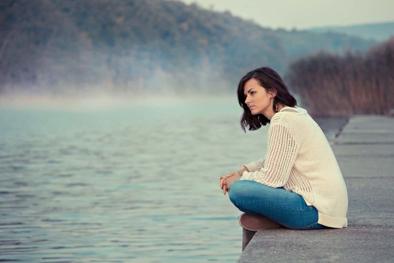 una mujer imaginaria sentada en un muelle