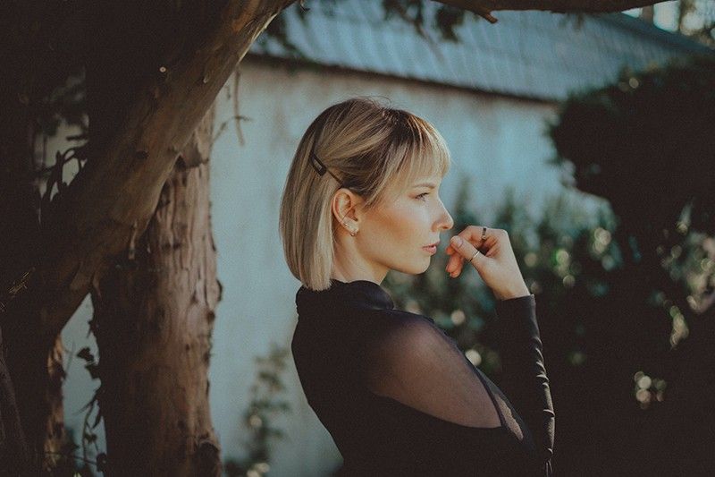 žena koja stoji u blizini stabla i izgleda zamišljeno
