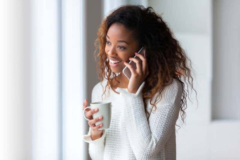 mosolygó fiatal lány beszél a telefonon