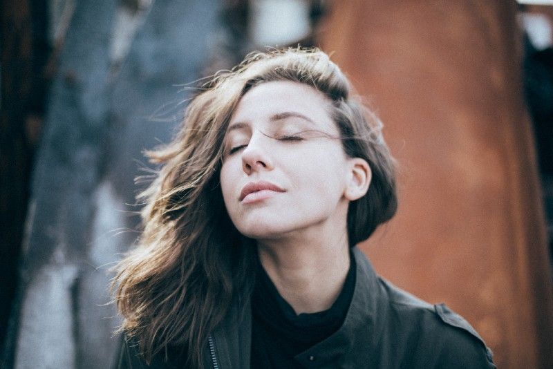 mulher de olhos fechados em pé ao ar livre