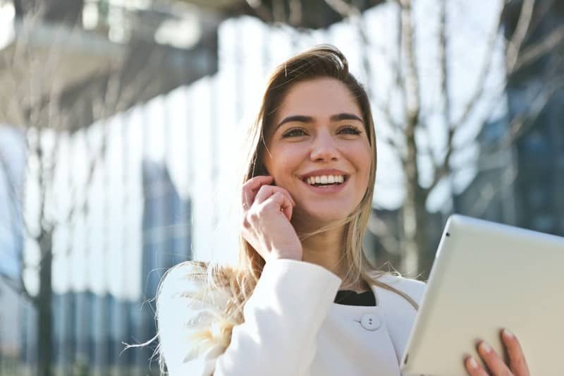 Frau, die am Telefon anruft und ihren Laptop nach draußen bringt