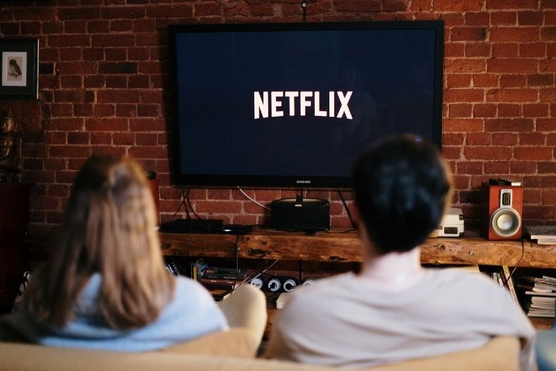 home i dona mirant la televisió asseguts al sofà