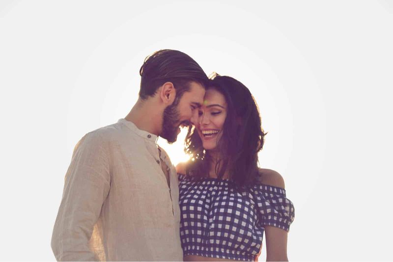 una coppia di innamorati sorridente in piedi che si abbraccia all
