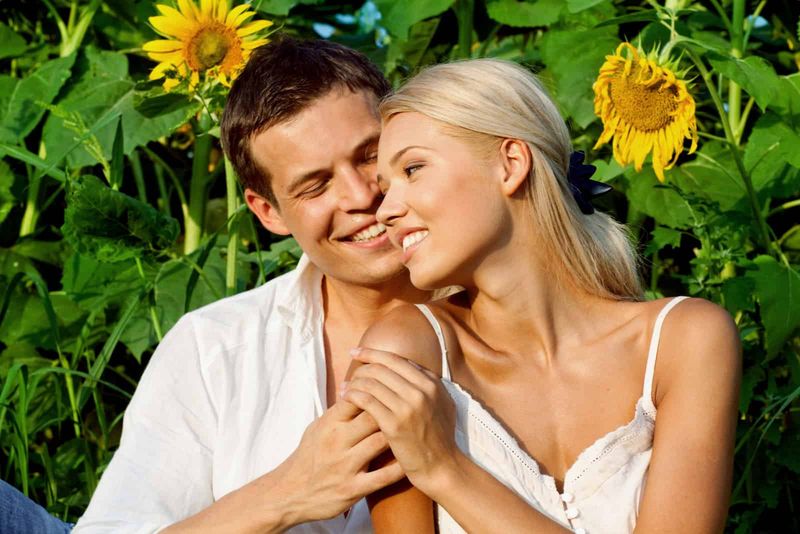một người đàn ông và một người phụ nữ nằm ôm nhau trên cánh đồng