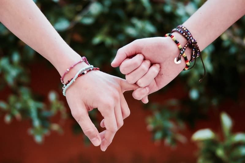 mãos adultas com carinho usando contas de vínculo de amizade
