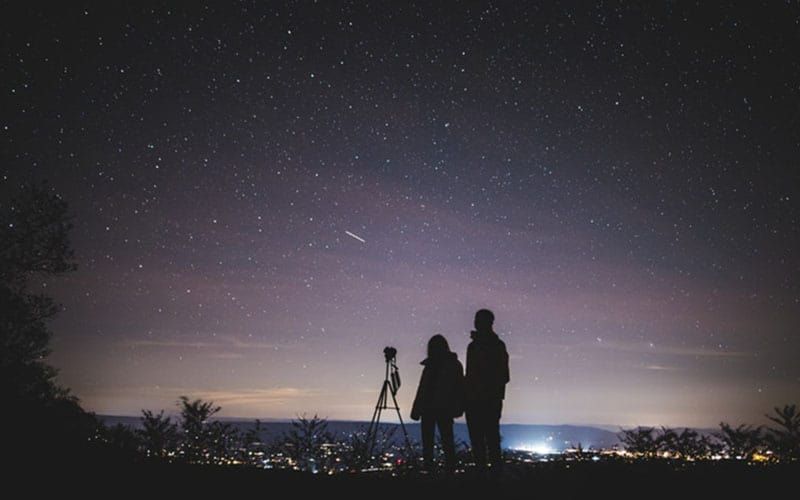 silhueta de duas pessoas em pé durante a noite