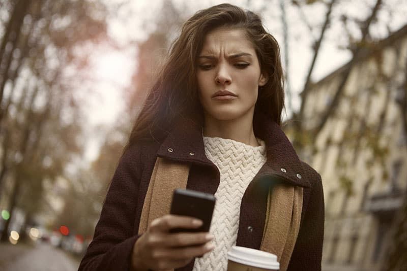 Mädchen, das wütend auf das Telefon schaut