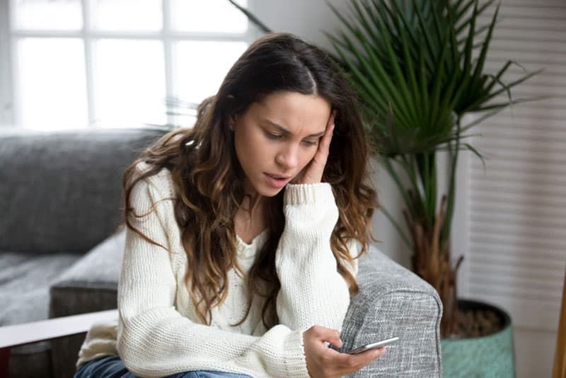 boos vrouw kijken naar haar telefoon