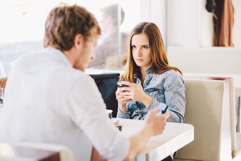 paar zitten in café en typen op hun smarphones