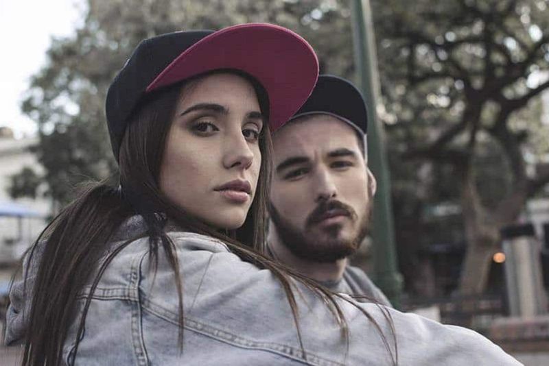 homem e mulher usando chapéu e olhando para a câmera