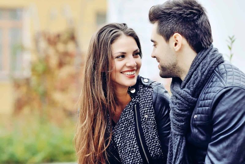 một người đàn ông và phụ nữ mỉm cười ngồi nói chuyện