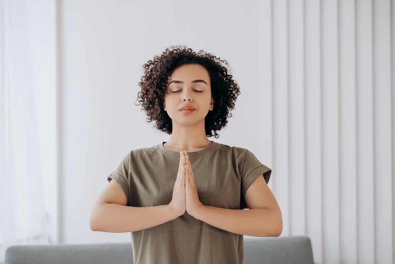 mirna ženska, ki meditira doma