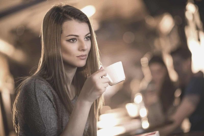 frumoasă femeie gânditoare care bea cafea în cafenea