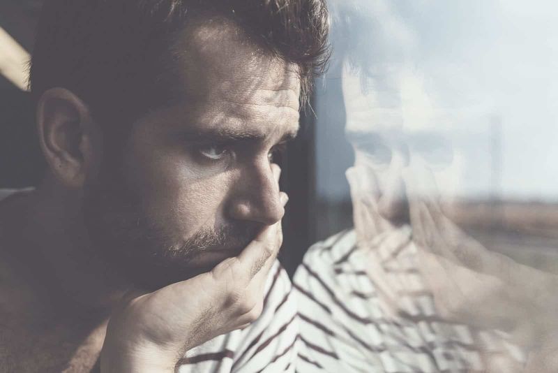 jovem triste sentado lamentando profundamente na fotografia de perto