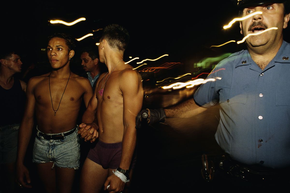 policial caminhando com manifestação pelos direitos gays