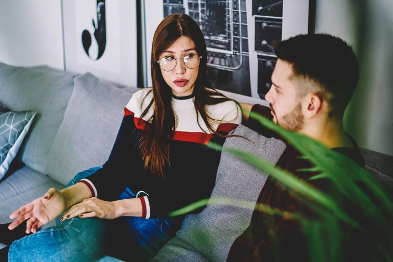 المرأة تتحدث إلى الرجل أثناء جلوسها على الأريكة