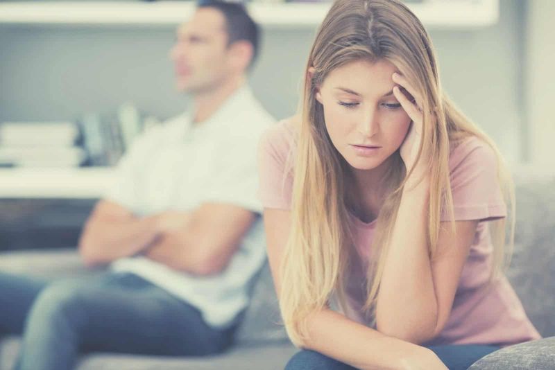 cặp đôi không nói chuyện sau một cuộc tranh cãi ngồi trên ghế sofa trong phòng khách