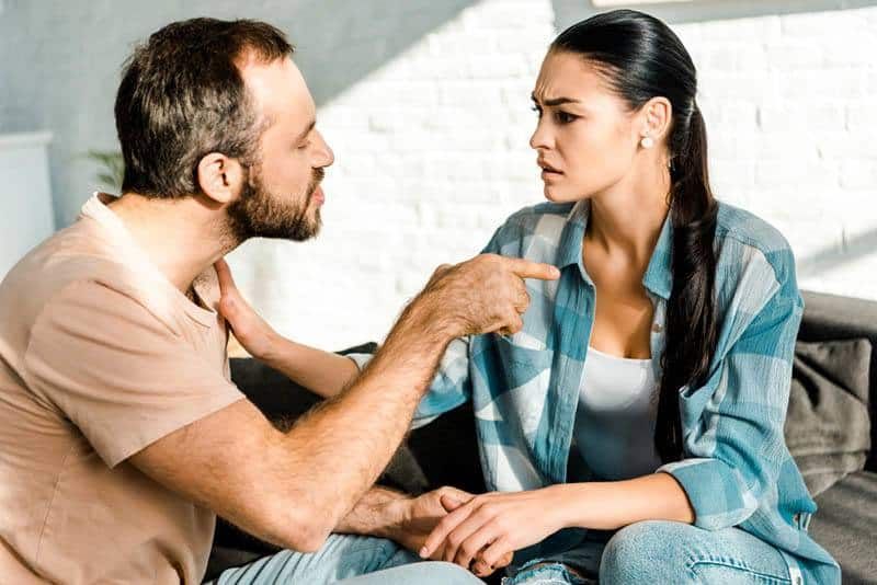 Verrückter Mann, der mit dem Finger auf eine Frau zeigt