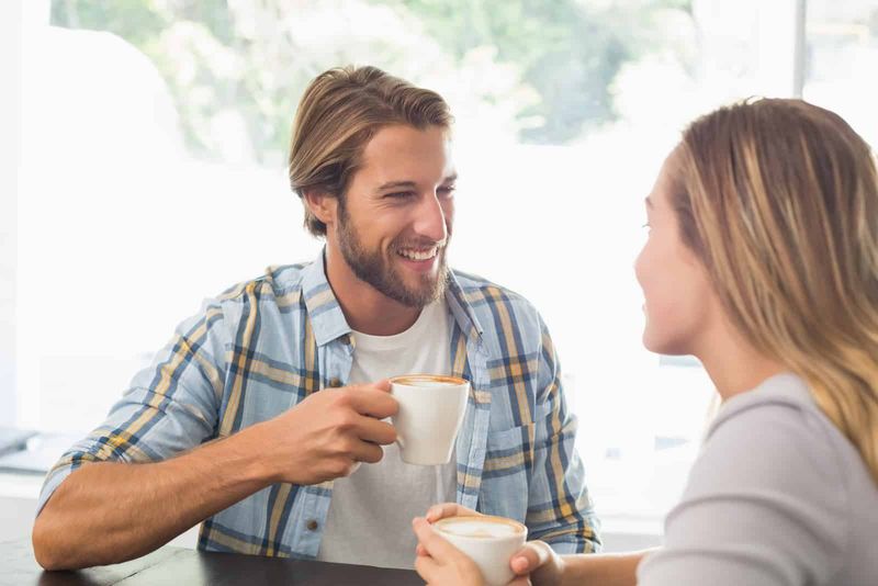 Pasangan bahagia menikmati kopi di kedai kopi