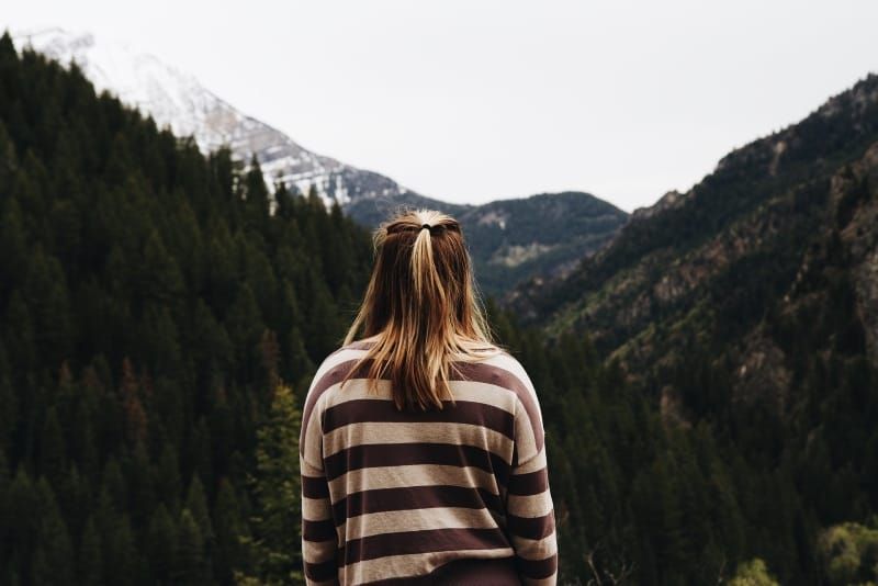 wanita berbaju bergaris melihat gunung