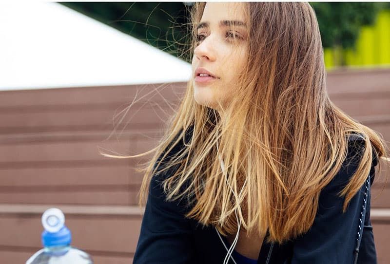 vrouw met een drankje terwijl ze denkt buiten te zitten