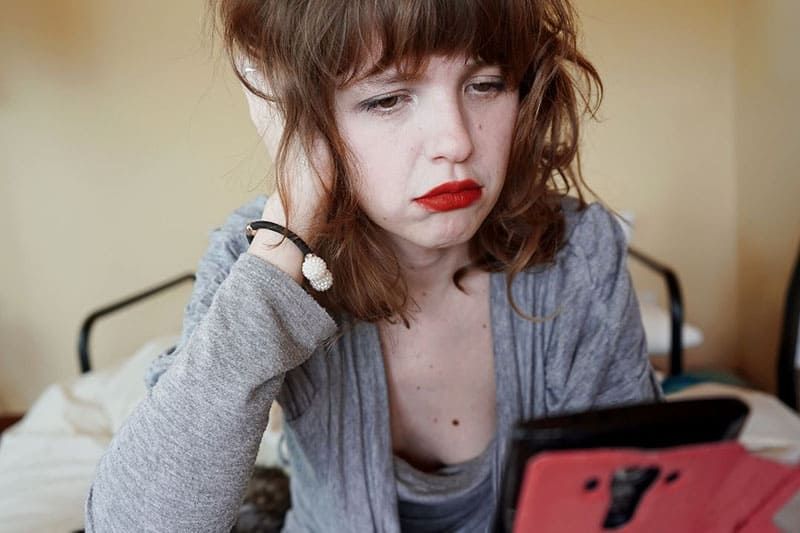 droevige vrouw in rode lippenstift die er droevig uitziet