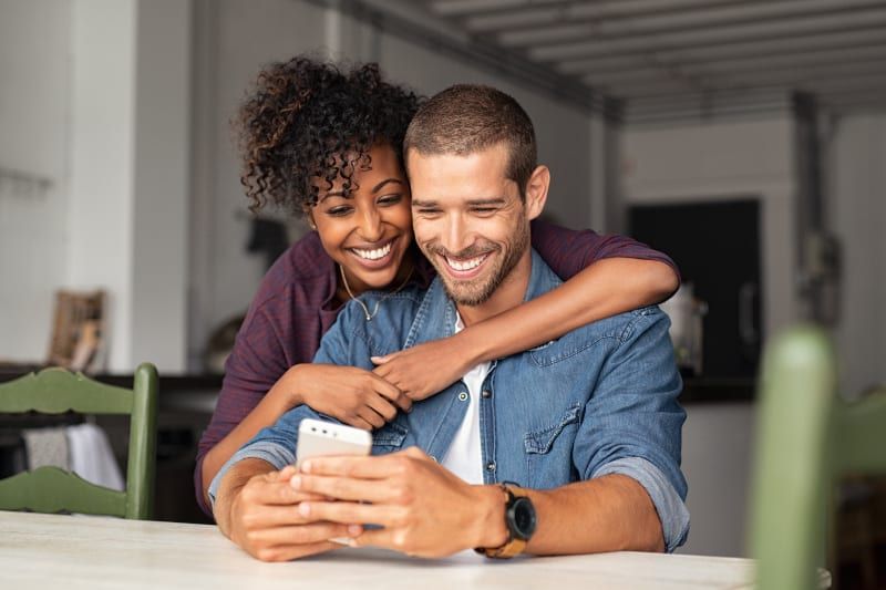 sonriente joven pareja abrazándose