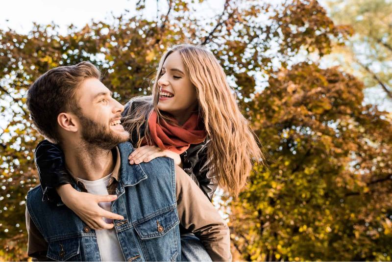 de man draagt ​​een lachende blonde vrouw