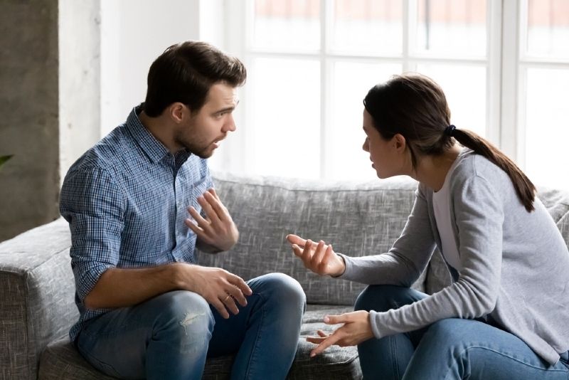 man en vrouw maken ruzie terwijl ze op de bank zitten