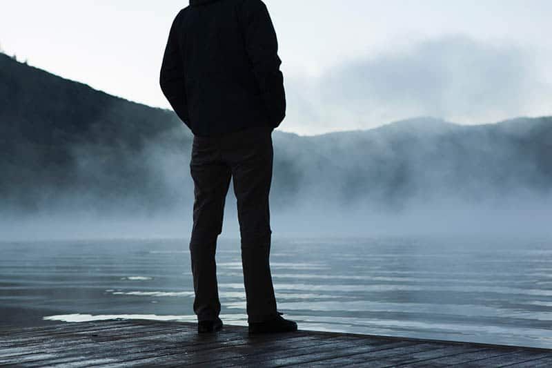 Mann, der allein am Wasser steht