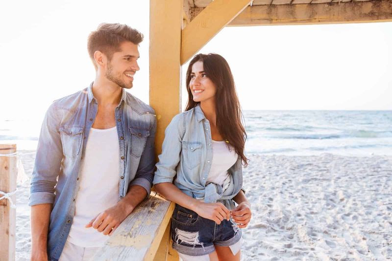 mężczyzna i kobieta flirtują stojąc na plaży