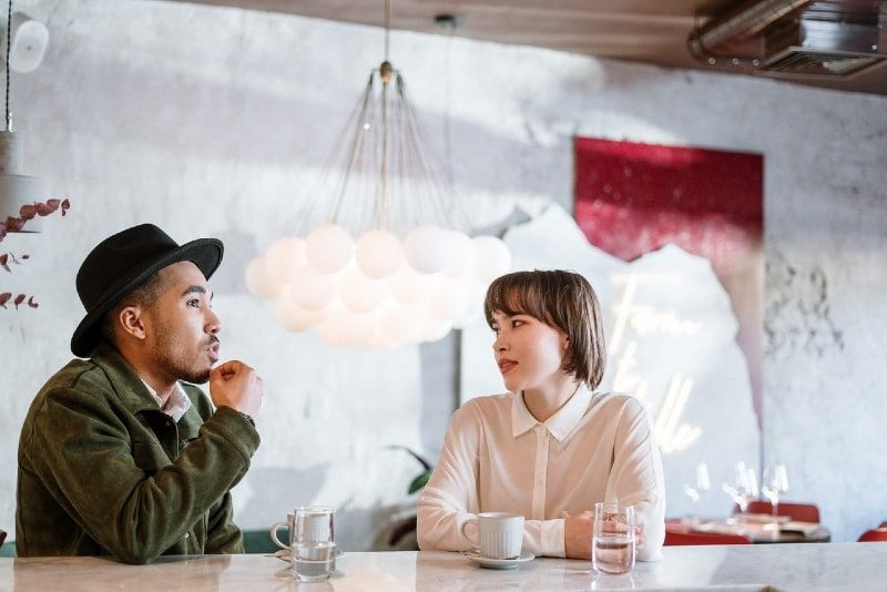 الرجل، ب، القبعة السوداء، تحدث إلى المرأة، بينما، جلس على table
