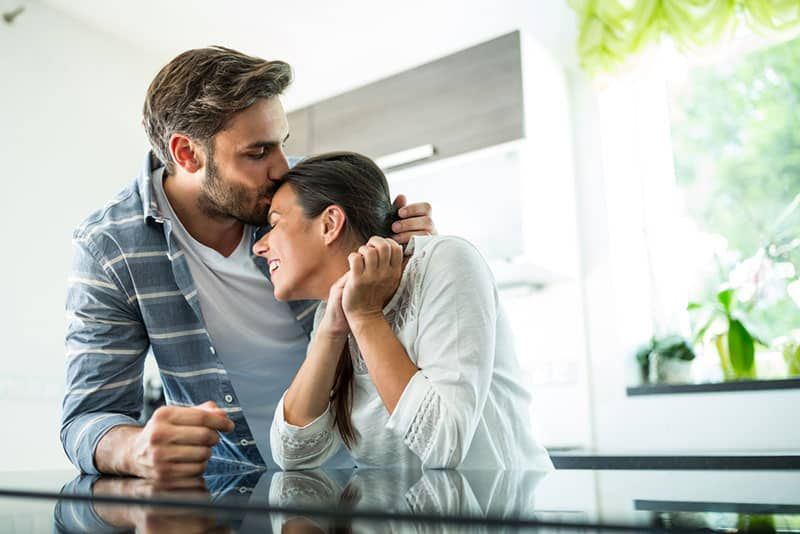 người đàn ông hôn vào đầu người phụ nữ