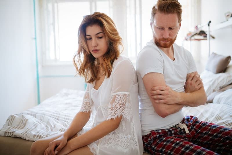 cặp vợ chồng không hạnh phúc ngồi trên giường