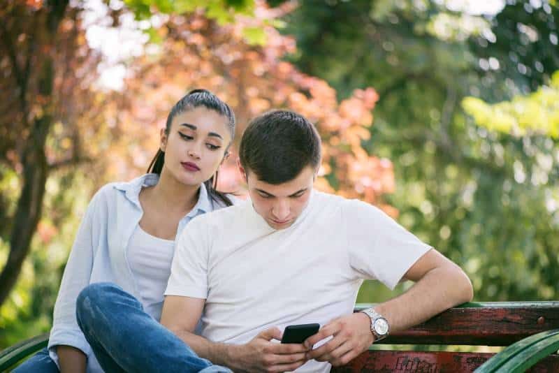 dona gelosa mirant el telèfon de l