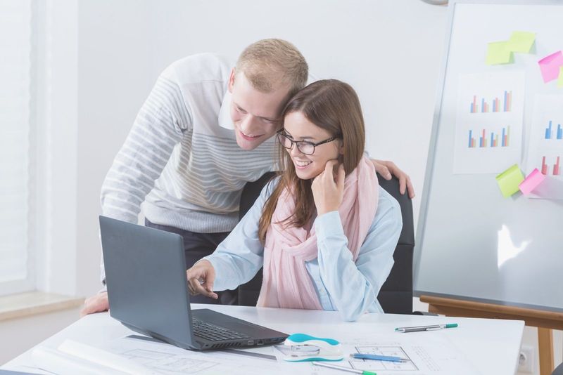 cuplu tânăr care lucrează la birou la un proiect