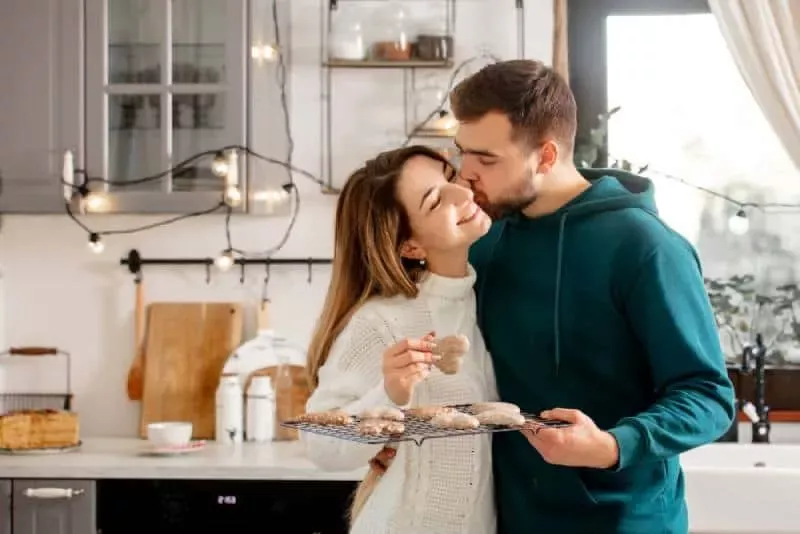   muž bozkáva svoju ženu na líce a drží sušienky