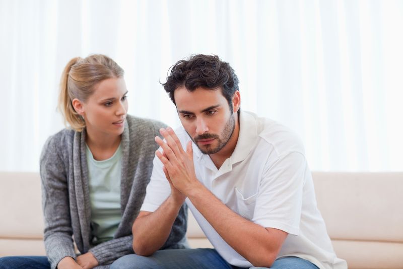 um casal triste sentado no sofá